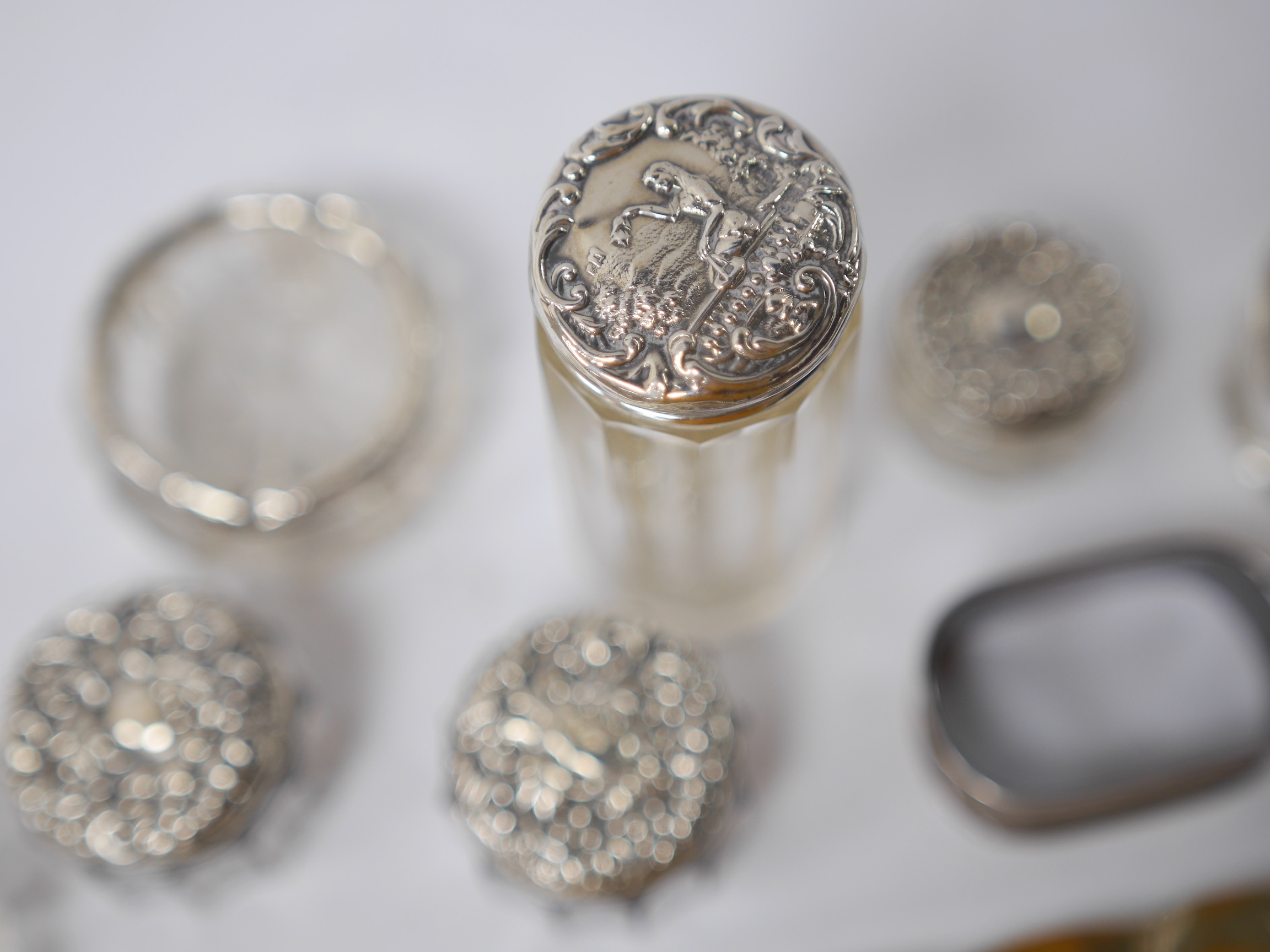 An Edwardian repousse silver dressing table tray by William Comyns, London, 1901, 23.3cm, together with four assorted silver mounted glass toilet jars, two silver mounted glass salts and three napkin rings. Condition - p